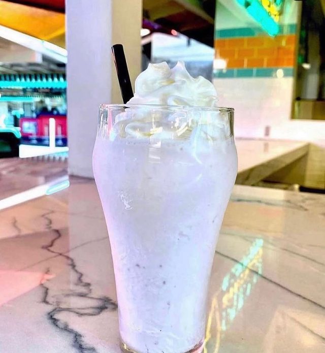 A tall pale shake on the counter.