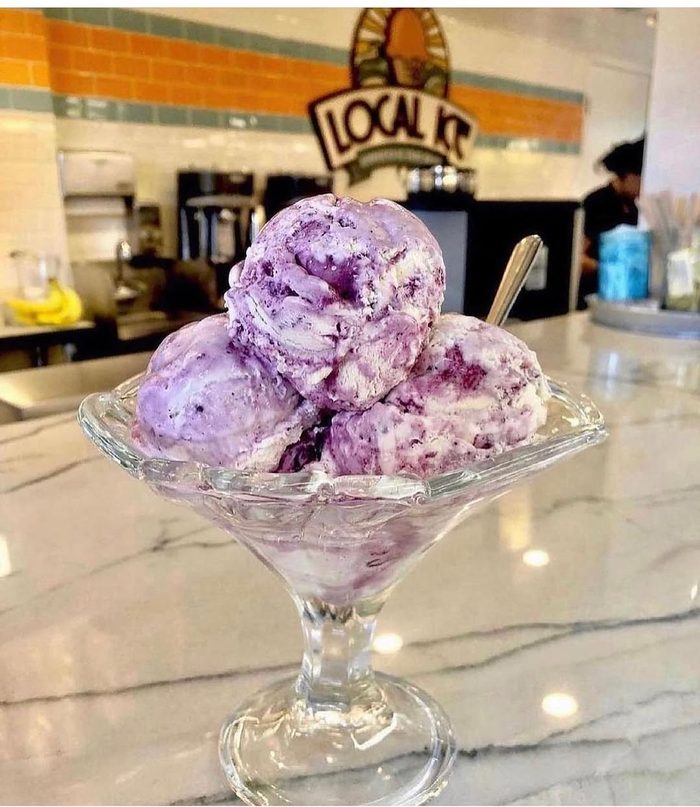 Scoops of deep purple ice cream in a glass coupe.